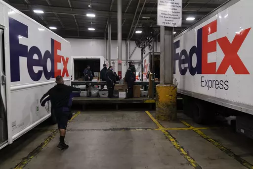 FedEx delivery trucks are parked next to a conveyor belt while being loaded with packages for delivery at the FedEx regional hub at the Los Angeles International Airport in Los Angeles, Dec. 7, 2021. Carriers like the U.S. Postal Service, FedEx and United Parcel Service have capacity to meet projected demand this holiday season, which is cheery news for shippers and shoppers alike. (AP Photo/Jae C. Hong)