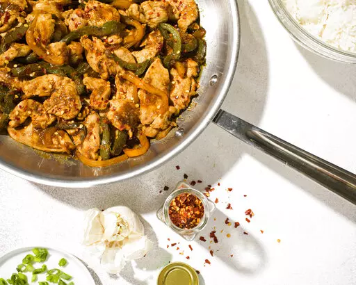 This image released by Milk Street shows a recipe for Stir-fried Hoisin Chicken and Bell Peppers. (Milk Street via AP)