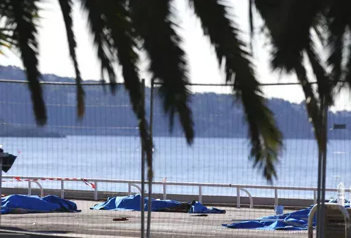 Bodies of victims covered by sheets at the scene of a truck attack in Nice, southern France, Friday, July 15, 2016. Eight people go on trial Monday Sept.5, 2022 in a special French terrorism court for alleged roles in helping the attacker who drove a truck into the Nice beachfront on Bastille Day 2016, killing 86 people. (AP Photo/Luca Bruno, File)