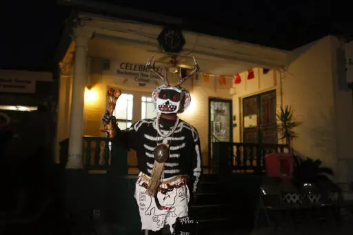 A member of the North Side Skull & Bone Gang starts the celebration with a wake up call for Mardi Gras at the Backstreet Cultural Museum, Feb. 9, 2016, in New Orleans. Ten months after Hurricane Ida damaged the museum celebrating New Orleans’ African American parading culture, it is reopening.  (AP Photo/Brynn Anderson, File)