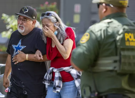 A woman cries as she leaves the Uvalde Civic Center, Tuesday May 24, 2022, in Uvalde, Texas, after a mass shooting. AA federal report into the halting and haphazard law enforcement response to a school shooting in Uvalde, Texas, was scheduled to be released Thursday, Jan. 18, 2024, reviving scrutiny of the hundreds of officers who responded to the 2022 massacre but waited more than an hour to confront and kill the gunman. (William Luther/The San Antonio Express-News via AP, File)