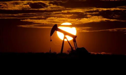The sun sets behind an idle pump jack near Karnes City, USA, April 8, 2020.  Oil markets have been fluctuating over fears of lost supplies from Russia because of the war in Ukraine. But the alliance of OPEC members and allied oil-producing countries are likely to steer a steady course when they decide production levels at an online meeting Thursday. The OPEC+ alliance has been opening the taps only gradually to restore cuts made during the worst of the pandemic recession. (AP Photo/Eric Gay, Fil