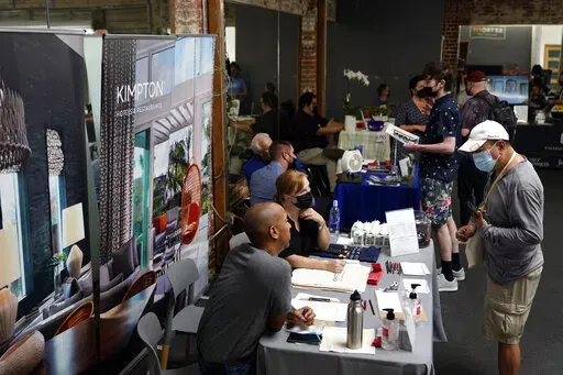 Prospective employers and job seekers interact during during a job fair on Sept. 22, 2021, in the West Hollywood section of Los Angeles. California's unemployment rate dipped a half-percentage point in December as the most populous state added 50,700 nonfarm jobs, accounting for more than a quarter of the nation's 199,000 job growth for the month, according to new data released Friday, Jan. 21, 2022. (AP Photo/Marcio Jose Sanchez, File)