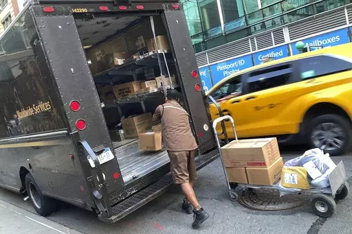 A United Parcel Service driver loads his truck, adjacent to a UPS Store, in New York, Thursday, May 11, 2023. Frustrated by what he called an "appalling counterproposal" earlier this week, the head of the union representing 340,000 UPS workers said a strike now appears inevitable and gave the shipping giant a Friday deadline to improve its offer. (AP Photo/Richard Drew, File)