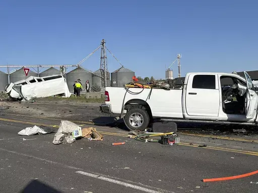 In this photo provided by KIFI Local News 8, a pickup truck crashed into a passenger van on U.S. Highway 20, Saturday, May 18, 2024, in Idaho Falls, Idaho. State police say the accident happened early Saturday morning when a pickup crossed the centerline on U.S. Highway 20 and fatally hit a passenger van. (Jeff Roper/KIFI Local News 8 via AP)