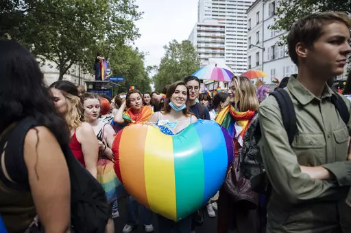 A participant holds a rainbow heart during the annual Gay Pride march in Paris, June 26, 2021. The National Assembly approved a new law unanimously Tuesday Jan. 25, 2022 evening, putting into law new measures that ban so-called conversion therapies and authorize jail time and fines for practitioners who use the scientifically discredited practice to attempt to change the sexual orientation or gender identity of LGBTQ people. The legislation includes criminal penalties for people who are convicte