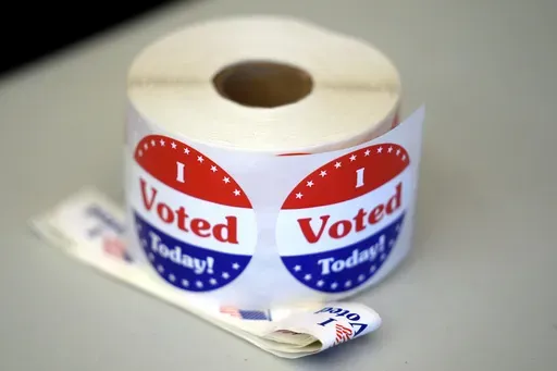 A spool of stickers rests on a table at a polling station during Massachusetts state primary voting, Sept. 3, 2024, in Newton, Mass. (AP Photo/Steven Senne, File)