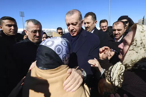 Turkey's President Recep Tayyip Erdogan and a survivor speak as he visits the city center destroyed by Monday earthquake in Kahramanmaras, southern Turkey, Wednesday, Feb. 8, 2023. Turkish President Recep Tayyip Erdogan came to power 20 years ago riding a wave of public outrage toward the previous government's handling of a deadly earthquake. Now, three months away from an election, Erdogan's political future hinges on how the public perceives his government's response to a similarly devastating