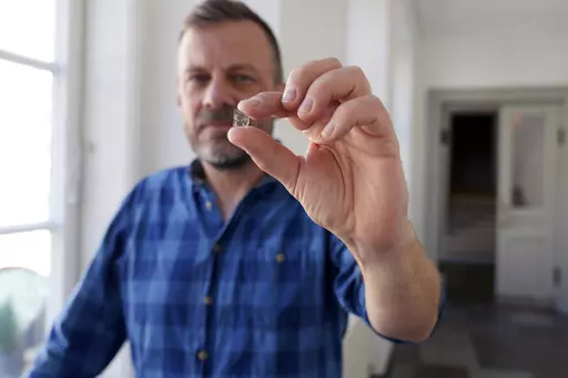 In this handout photo released on Thursday, Oct. 5, 2023, Senior Researcher at the National Museum of Denmark Mads Dengso Jessen holds a window glass fragment from the Viking Age, in Copenhagen, Denmark, Sept. 8, 2023. Over the past 25 years, archaeologists have found glass fragments in six excavations in southern Sweden, Denmark and northern Germany and have analyzed fragments of glass panes to reach the conclusion: Vikings had windows with glass-panes. (John Fhær Engedal Nissen/The National M