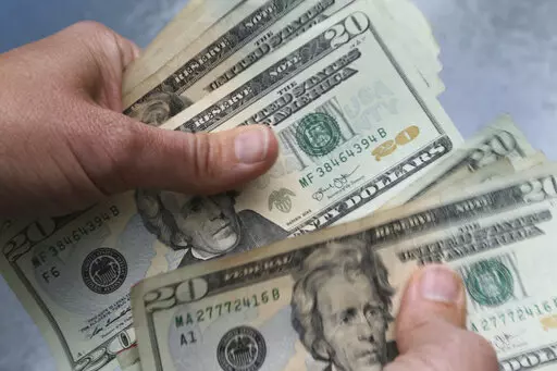 In this June 15, 2018 file photo, twenty dollar bills are counted in North Andover, Mass. Rising prices can feel impossible to manage if money is already tight. To stay afloat, prioritize essential expenses that enable you to live and work.  (AP Photo/Elise Amendola, File)
