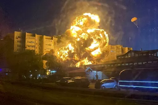 In this handout photo released by Kooperativ Telegram Channel, flames and smoke rise from the scene after a warplane crashed into a residential area in Yeysk, Russia, Monday, Oct. 17, 2022. The Russian military says one of its warplanes has crashed near an apartment building in Yeysk, a port city on the Sea of Azov, after experiencing engine failure on takeoff. The crash ignited a huge fire, killing at least four people, leaving six missing and injuring 21 others, eight of whom were in grave con