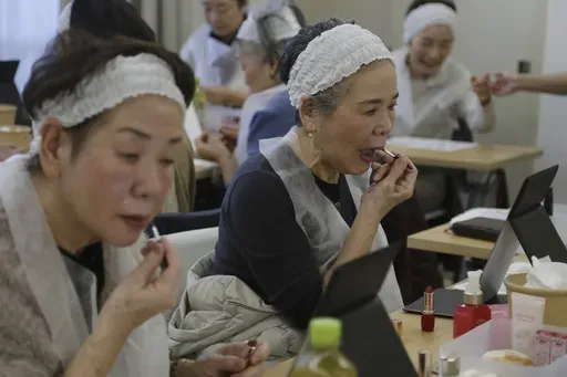 Women try on the lipstick of the color they like as they take part in a special makeup class at a community center room in Tokyo, on Feb. 14, 2025. (AP Photo/Yuri Kageyama)