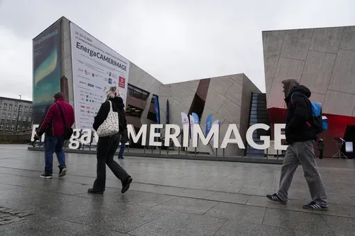 People walk in front of the venue of the 32nd Camerimage International Film Festival in Torun, Poland, Wednesday, Nov. 20, 2024. (AP Photo/Czarek Sokolowski)
