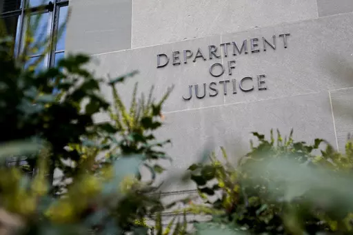 A sign marks an entrance to the Robert F. Kennedy Department of Justice Building in Washington, Jan. 23, 2023. The Justice Department proposed changes Monday, Feb. 5, 2024, to rules governing state-run programs that provide financial assistance to violent crime victims in order to address racial disparities and curb the number of subjective denials of compensation. (AP Photo/Patrick Semansky, File)