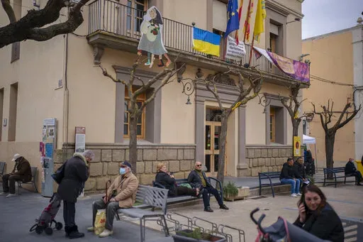 A Ukrainian flag is displayed on the Town Hall of the village of Guissona in Lleida, Spain, Thursday, March 17, 2022. Long before Russian tanks rolled into Ukraine, the tiny town of Guissona was known as "Little Ukraine" – one in seven residents were originally from the country, most of them lured to this northeastern Spanish town by jobs at a supermarket distribution hub. (AP Photo/Joan Mateu Parra)