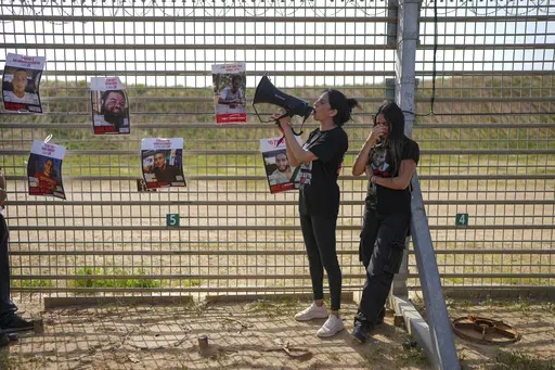Relatives of hostage held by Hamas in the Gaza Strip, stand by the Israe-Gaza border fence, calling for their release and expressing concerns that the resumption of fighting in Gaza puts their loved ones at risk, in southern Israel, Tuesday, March 18, 2025. (AP Photo/Ohad Zwigenberg)
