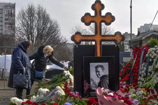 Russian opposition leader Alexei Navalny's mother, Lyudmila Navalnaya, left, and his mother-in-law, no name available, visit the grave of Alexei Navalny after his yesterday funeral at the Borisovskoye Cemetery, in Moscow, Russia, on Saturday, March 2, 2024. Navalny, who was President Vladimir Putin's fiercest foe, was buried after a funeral that drew thousands of mourners amid a heavy police presence. (AP Photo)