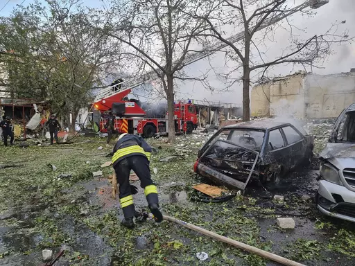 In this photo provided by the Ukrainian Emergency Service, emergency services personnel work to extinguish a fire following a Russian attack in Cherkasy, Ukraine, Thursday, Sept. 21, 2023. (Ukrainian Emergency Service via AP)