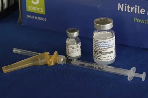 A syringe lies next to vials of COVID-19 booster vaccines at an inoculation station in Jackson, Miss., Friday, Nov. 18, 2022. (AP Photo/Rogelio V. Solis, File)