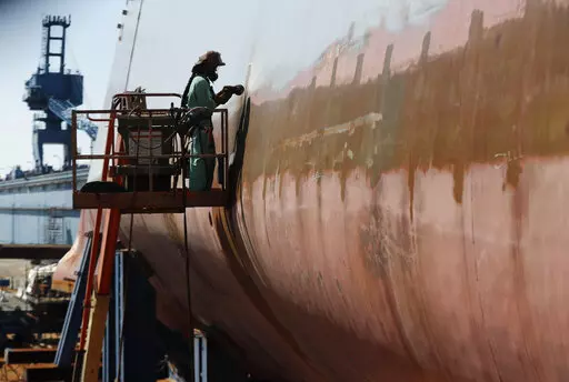 FILE — Welder Neal Larsen works on the hull of a Zumwalt-class destroyer Aug. 29, 2018, being built in the shipyard at Bath Iron Works in Bath, Maine. The U.S. Navy, following costly lessons after cramming too much new technology onto warships and speeding them into production, is slowing down the design and purchase of its next-generation destroyer, and taking extra steps to ensure new technology like lasers and hypersonic missiles have matured before pressing ahead. (AP Photo/Robert F. Bukat