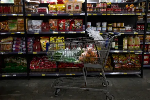 A shopping cart filled with groceries sits in an aisle at an Asian grocery store in Rowland Heights, Calif., Thursday, April 3, 2025. (AP Photo/Jae C. Hong)