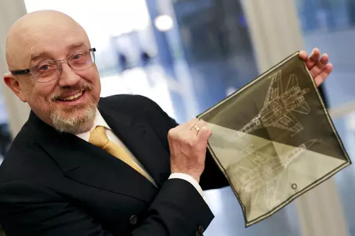 CAPTION CORRECTS THE ID - Ukraine's Defense Minister Oleksiy Reznikov shows a handkerchief with a F-35 fighter jet when heading to a meeting with United States Secretary of Defense Lloyd Austin, on the sidelines of a NATO headquarters in Brussels, Tuesday, Feb. 14, 2023. (AP Photo/Olivier Matthys, Pool)