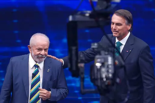 Brazil's former President Luiz Inacio Lula da Silva, who is running for office again, left, faces Jair Bolsonaro in a presidential debate at Bandeirantes Television in Sao Paulo, Brazil, Sunday, Oct. 16, 2022. The presidential runoff election is set for Oct. 30. (AP Photo/Marcelo Chello)