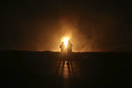 Two men look at flames after a natural gas pipeline explodes outside the city of Boroujen in the western Chaharmahal and Bakhtiari province, Iran, in early Wednesday, Feb. 14, 2024. Explosions struck a natural gas pipeline in Iran early Wednesday, with an official blaming the blasts on a "sabotage and terrorist action" in the country as tensions remain high in the Middle East amid Israel's war on Hamas in the Gaza Strip. (Reza Kamali Dehkordi/Fars News Agency via AP)