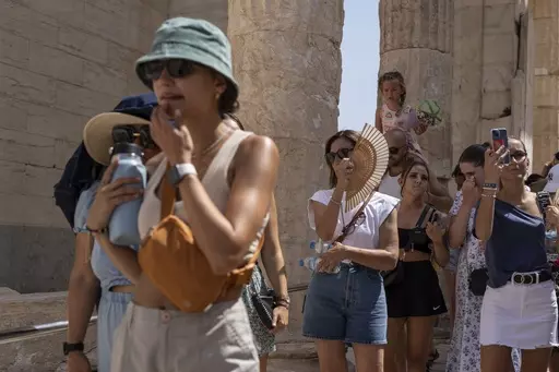 Tourists visit the ancient Acropolis hill during a heat wave in Athens, Greece, on July 21, 2023. Climate change is making heat waves crawl slower across the globe and last longer with higher temperatures over larger areas, a new study finds. (AP Photo/Petros Giannakouris, File)