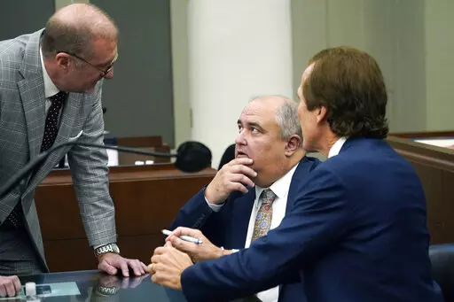 John Davis, former director of the Mississippi Department of Human Services, confers with defense attorneys Merrida Coxwell, right, and Charles Mullins, left, in Jackson, Miss., on Sept. 22, 2022. Davis pleaded guilty to state and federal charges in a conspiracy to misspend tens of millions of dollars that were intended to help needy families in one of the poorest states in the U.S. as part of the largest public corruption case in Mississippi history. (AP Photo/Rogelio V. Solis, File)