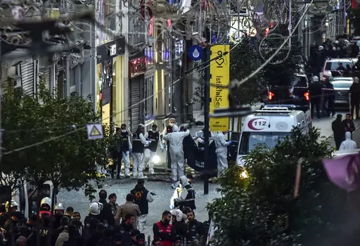Forensic experts collect a dead body after an explosion on Istanbul's popular pedestrian Istiklal Avenue Sunday, Istanbul, Sunday, Nov. 13, 2022. An explosion on one of Istanbul's most popular pedestrian thoroughfares killed a handful of people and injured dozens on Sunday, authorities said. The cause of the blast on Istiklal Avenue was not immediately clear. Five prosecutors were assigned to investigate the explosion, state-run Anadolu news agency said.(Ismail Coskun/IHA via AP)