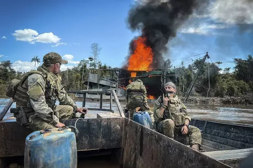 In this image provided by IBAMA, Brazil's Environmental Agency, federal agents destroy an illegal mining barge inside Yanomami Indigenous territory, Roraima state, Brazil, Tuesday, March 14, 2023. On Tuesday, federal agents seized multiple Starlink unit, an internet kit that provides high-speed connections even in remote places in Brazil's Amazon, like this mining pit. (IBAMA via AP)