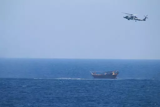 A U.S. Navy Seahawk helicopter flies over a stateless dhow later found to be carrying a hidden arms shipment in the Arabian Sea, May 6, 2021. The U.S. Navy's Mideast-based 5th Fleet will begin Tuesday, July 5, 2022, to offer rewards for information that could help sailors intercept weapons, drugs and other illicit shipments across the region. The program launches against the backdrop of tensions over Iran’s nuclear program and Tehran’s arming of Yemen’s Houthi rebels. (U.S. Navy via AP, Fi