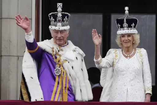 Britain's King Charles III and Queen Camilla wave to the crowds from the balcony of Buckingham Palace after the coronation ceremony in London, Saturday, May 6, 2023. (AP Photo/Frank Augstein)