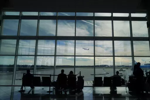 Travelers watch as a plane takes off from Hartsfield-Jackson Atlanta International Airport in Atlanta, Tuesday, Nov. 22, 2022. On Friday, Jan. 27, 2023, The Associated Press reported on stories circulating online incorrectly claiming the FAA loosened the requirements that airline pilots must meet for cardiac health because of COVID-19 vaccine side effects. (AP Photo/Brynn Anderson, File)