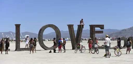 Participants walk around at the Burning Man festival on the Black Rock Desert of Gerlach, Nev., on Aug. 27, 2014. Burning Man organizers don't foresee major changes in 2024 thanks to a hard-won passing grade for cleaning up this year's festival. (Andy Barron/The Reno Gazette-Journal via AP, File)