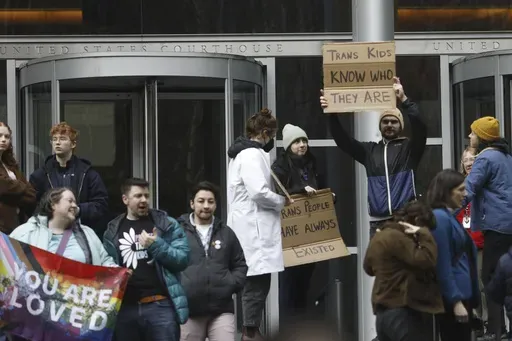 People celebrate outside a Seattle federal courthouse after a second federal judge paused President Donald Trump's order against gender-affirming care for youth on Friday, Feb. 14, 2025 in Seattle.. (AP Photo/Manuel Valdes)