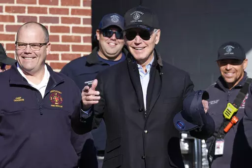 President Joe Biden, center, standing next to Nantucket Fire Department Chief Michael Cranson, left, talks during a visit with firefighters on Thanksgiving Day at the Nantucket Fire Department in Nantucket, Mass., Thursday, Nov. 24, 2022. (AP Photo/Susan Walsh)
