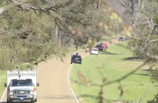 This image taken from video provided by WAPT shows first responders working the scene after a medical transport helicopter crashed Monday, March 10, 2025, in Madison County, Miss. (WAPT via AP)