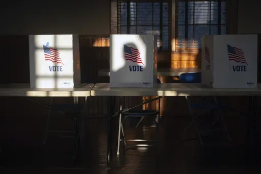 The shadow of a voter entering the precinct at St. Joseph Catholic Church in Gluckstadt, Miss., is cast on a privacy divider for people filling out ballots at Precinct 205 at during the primary election on March 12, 2024. (Barbara Gauntt/The Clarion-Ledger via AP)