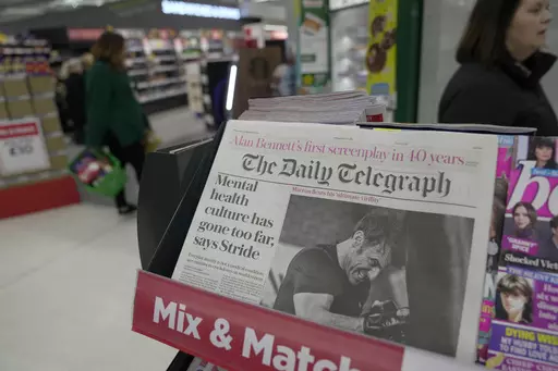 A newspaper with the front page of French President Emanuel Macron is seen at a supermarket in London, Thursday, March 21, 2024. (AP Photo/Kin Cheung)