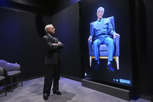 Jack Jacobs, a retired U.S. Army colonel who was awarded the Medal of Honor for his actions during the Vietnam War, interacts with his likeness on a video screen by asking it a question at the National Medal of Honor Museum in Arlington, Texas, Thursday, March 13, 2025. (AP Photo/Tony Gutierrez)