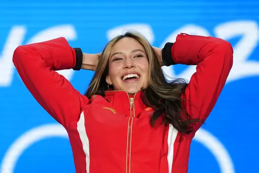 Gold medalist Eileen Gu of China celebrates during the medal ceremony for the women's freestyle skiing big air at the 2022 Winter Olympics, Tuesday, Feb. 8, 2022, in Beijing. (AP Photo/Natacha Pisarenko)