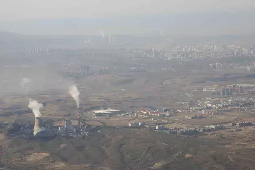 Smoke and steam rise from towers at the coal-fired Urumqi Thermal Power Plant as seen from a plane in Urumqi in western China's Xinjiang Uyghur Autonomous Region on April 21, 2021. China is promoting coal-fired power as the ruling Communist Party tries to revive a sluggish economy, prompting warnings that Beijing is setting back efforts to cut climate-changing carbon emissions from the biggest global source. (AP Photo/Mark Schiefelbein, File)