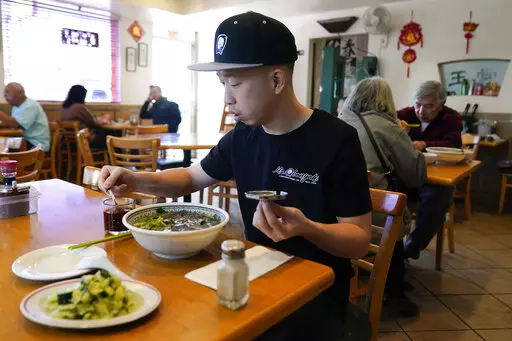 Kevin Mok, owner of Mr Obanyaki ice cream shop, near the Star Ballroom Dance Studio, eats noodles at Mandarin Noodle House on Tuesday, Jan. 24, 2023, in Monterey Park, Calif. A gunman killed multiple people at the ballroom dance studio late Saturday amid Lunar New Years celebrations in the predominantly Asian American community. (AP Photo/Ashley Landis)