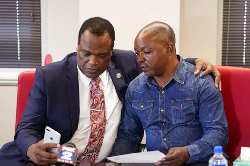 Kent County Commissioner Robert Womack shows Peter Lyoya the broadcast feed in attorney Ven Johnson's office, Thursday, June 9, 2022, in Detroit. A Michigan police officer who killed Peter's son, Patrick Lyoya, with a shot to the back of the Black man's head has been charged with second-degree murder. Prosecutor Chris Becker announced the charges Thursday against Grand Rapids Officer Christopher Schurr, weeks after Lyoya was killed following a chaotic traffic stop on April 4. (AP Photo/Carlos Os