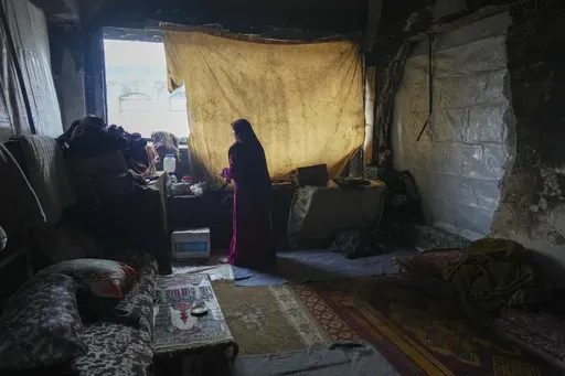 Hanan Okal, 22, prepares breakfast for her children inside a classroom in the Jabaliya Girls Preparatory School, which displaced people use as a shelter, in the Jabaliya refugee camp in the northern Gaza Strip, Monday, Feb. 10, 2025. (AP Photo/Abdel Kareem Hana)