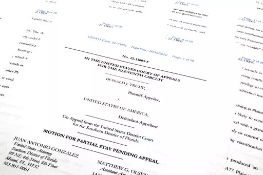 Pages from the Justice Department's motion to the 11th Circuit U.S. Court of Appeals in Atlanta are photographed Friday, Sept. 16, 2022. The Justice Department asked the federal appeals court to lift a judge's order that temporarily barred it from reviewing a batch of classified documents seized during an FBI search of former President Donald Trump's Florida home last month. (AP Photo/Jon Elswick)