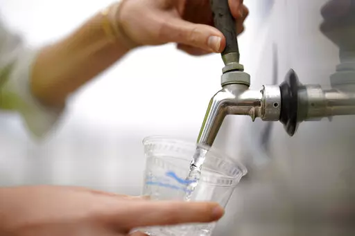 An official at the Carlsbad Desalination plant fills a cup with filtered water made from ocean water, Thursday, May 26, 2022, in Carlsbad, Calif.The facility is the Western hemisphere's largest desalination plant, which removes salt and impurities from ocean water. (AP Photo/Gregory Bull)