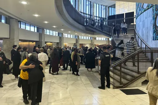 People arrive at Parliament in Wellington, New Zealand, on Wednesday, July 24, 2024, for the tabling of a wide-ranging independent inquiry into the abuse of children and vulnerable adults in care over the span of five decades wrote in a blistering final report. (AP Photo/Charlotte Graham-McLay)